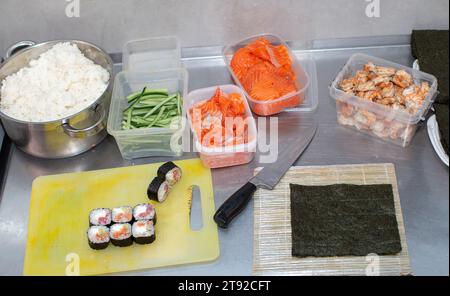 Préparer des sushis. Nori et d'autres ingrédients sont disposés sur la table d'un restaurant japonais pour le processus de préparation de rouleaux de sushi. Banque D'Images