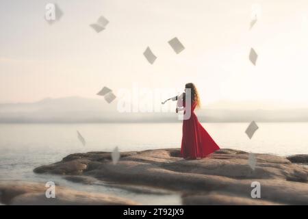 moment surréaliste de partition dansant dans le ciel dans le temps à la musique de violon d'une femme en jeu rouge Banque D'Images