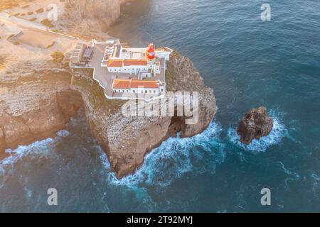 Un sommet les falaises accidentées de Cabo de São Vicente, Farol do Cabo de São Vicente phare, vue panoramique sur l'océan Atlantique. Région de l'Algarve. Antenne Banque D'Images