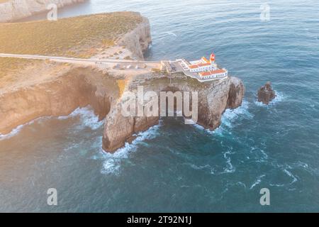 Un sommet les falaises accidentées de Cabo de São Vicente, Farol do Cabo de São Vicente phare, vue panoramique sur l'océan Atlantique. Région de l'Algarve. Antenne Banque D'Images