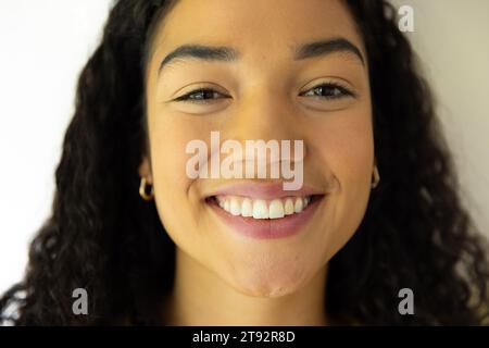 Gros plan portrait de femme biracial heureuse en pull jaune à la maison Banque D'Images