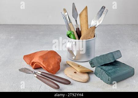 Ensemble d'outils pour sculpter et modeler et des pièces de plasticine et d'argile sur une table en béton léger Banque D'Images