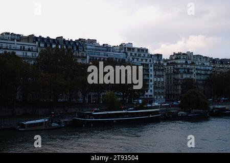 Skyline de Paris avec des bâtiments, des bateaux sur l'eau et un ciel nuageux dans le 15e arrondissement Banque D'Images