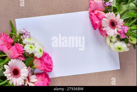 Beau bouquet de fleurs roses sur le coin d'un papier de carte de voeux blanc vierge avec espace pour le texte. Carte plate Lay pour joyeux anniversaire, félicitations Banque D'Images