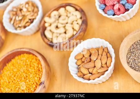 amandes et lentilles près de l'assortiment d'aliments sains à base de plantes dans des bols, concept végétarien Banque D'Images