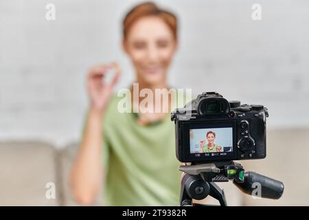 focus sur l'appareil photo numérique devant la femme végétarienne heureuse avec de la nourriture à base de plantes, la création de contenu Banque D'Images