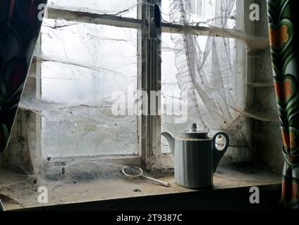 DATE RECORD NON INDIQUÉE mit Spinnweben überzogenes Küchenfenster in einem verlassenen Haus. *** Fenêtre de cuisine couverte de toiles d'araignée dans une maison abandonnée Banque D'Images