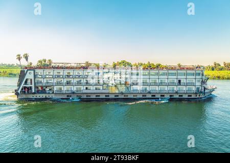 Les vendeurs de textiles sur leurs bateaux approchent un bateau de croisière en attendant d'entrer dans l'écluse d'Esna. Les vendeurs espèrent vendre des marchandises aux touristes. Esna, Égypte – octobre 20 Banque D'Images