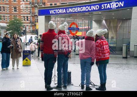 Londres, Royaume-Uni, 21 novembre 2021 : les touristes regardent quatre buskers en sauteurs festifs chanter des chansons de Noël à Cardinal place, près de la gare et de la station de métro Victoria. Anna Watson/Alamy Live News Banque D'Images