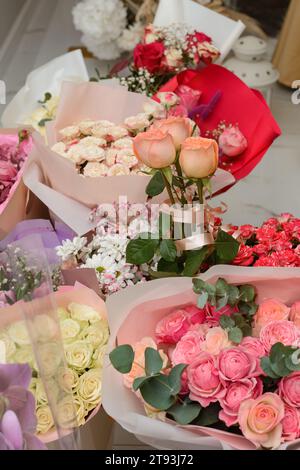 Bouquets prêts de roses en papier cadeau, vue de dessus de la reine des fleurs. Banque D'Images