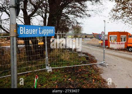 Heide, Allemagne. 22 novembre 2023. Un panneau routier avec l'inscription 'Blauer Lappenn' (chiffon bleu) se dresse à l'entrée d'un chantier dans le quartier Lohe-Rickelshof de Dithmarschen. L'usine de batteries Northvolt pour voitures électriques doit être construite ici. Cependant, suite à la décision budgétaire de la Cour constitutionnelle fédérale, on ne sait toujours pas ce qui se passera avec le financement fédéral prévu pour la construction. La société Northvolt prévoit des coûts d’environ 4,5 milliards d’euros. (Vue aérienne avec un drone) crédit : Frank Molter/dpa/Alamy Live News Banque D'Images