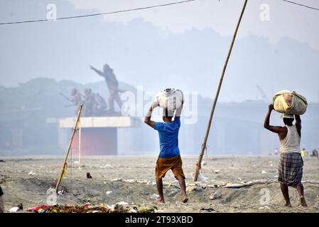 Guwahati, Guwahati, Inde. 22 novembre 2023. Laveuse homme porter des vêtements après le lavage dans la rivière Brahmapoutre à Guwahati Assam Inde le mercredi 22 novembre 2023 (image de crédit : © Dasarath Deka/ZUMA Press Wire) USAGE ÉDITORIAL SEULEMENT! Non destiné à UN USAGE commercial ! Banque D'Images