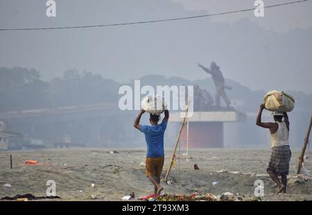 Guwahati, Guwahati, Inde. 22 novembre 2023. Laveuse homme porter des vêtements après le lavage dans la rivière Brahmapoutre à Guwahati Assam Inde le mercredi 22 novembre 2023 (image de crédit : © Dasarath Deka/ZUMA Press Wire) USAGE ÉDITORIAL SEULEMENT! Non destiné à UN USAGE commercial ! Banque D'Images