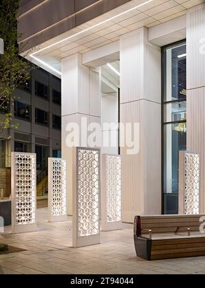 Vue au crépuscule vers l'entrée du bâtiment. Altus House, Leeds, Royaume-Uni. Architecte : O'Connell East Architects, 2022. Banque D'Images