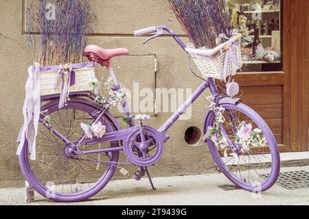 Un vélo violet décoré se dresse dans une rue à Olite, Navarre, Espagne Banque D'Images