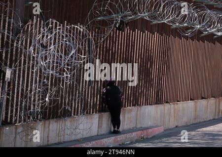 Nogales, Arizona, États-Unis. 21 novembre 2023. Une femme à Nogales, Arizona, parle à une personne à Nogales, Sonora à travers la clôture du mur frontalier. (Image de crédit : © Christopher Brown/ZUMA Press Wire) USAGE ÉDITORIAL SEULEMENT! Non destiné à UN USAGE commercial ! Banque D'Images