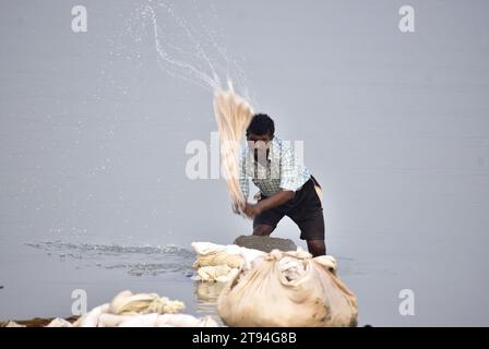 Guwahati, Inde. 22 novembre 2023. Laveur homme lave les vêtements sur la rive de la rivière Brahmapoutre à Guwahati. (Image de crédit : © Dasarath Deka/ZUMA Press Wire) USAGE ÉDITORIAL SEULEMENT! Non destiné à UN USAGE commercial ! Banque D'Images