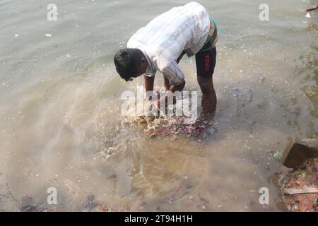 Dhaka Bangladesh,23 novembre 2023,un vendeur de légumes bangladais a lavé des légumes verts dans une eau polluée à dhaka.cette photo a été prise par kuril purba Banque D'Images