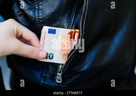 Tire la main du papier-monnaie et de la carte hors de sa poche. Un voleur a volé un homme. Vol d'argent, concept criminel. Banque D'Images