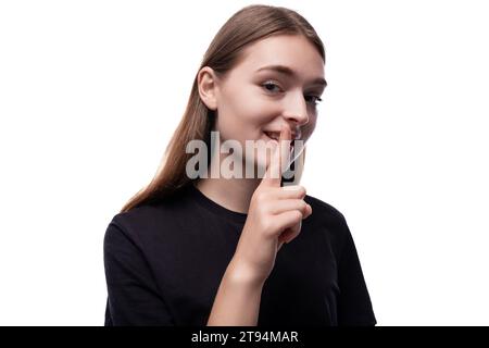 Mignonne adolescente sly aux cheveux clairs dans un T-shirt noir Banque D'Images