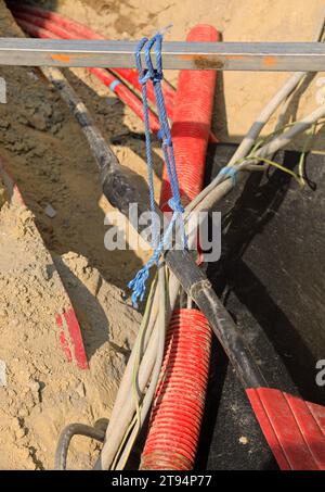 jonction électrique entre des câbles électriques haute tension à l'intérieur de l'excavation d'un chantier de construction routière pour la réparation de la ligne électrique Banque D'Images