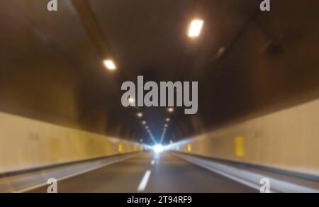 volontairement flou tunnel routier asphalté sans voitures et vous voyez la lumière au loin, idéal comme concept d'espoir Banque D'Images