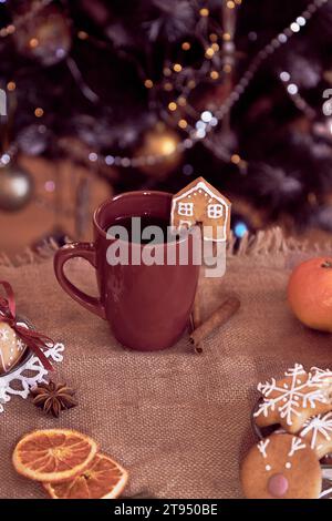 Mise en place de la table d'hiver. Nourriture de Noël esthétique - maisons de biscuits au gingembre et chocolat chaud. Maison chaleureuse et confortable. Fond de Noël. Banque D'Images