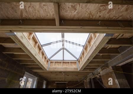 Construction d'un puits de lumière moderne dans un toit encadré en bois pendant le processus de construction Banque D'Images