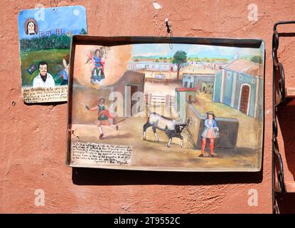 Peinture folklorique d'art Naïve mexicaine représentant la scène rurale du XVIIIe siècle, sur des plateaux métalliques accrochés au mur à l'extérieur Banque D'Images