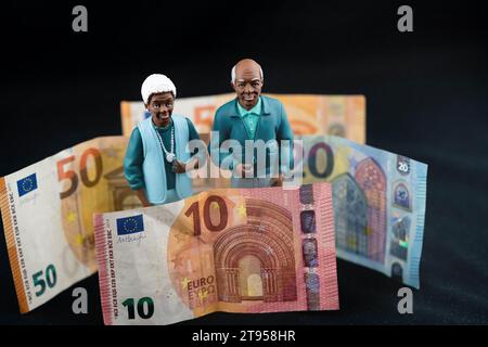 Couple senior noir avec pièce en euro, salaire de retraite Banque D'Images