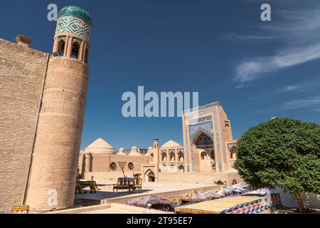 Le Kutlimurodinok Madrasah à côté de Islam Hoja Minaret dans la forteresse Ichon-Qala, la vieille ville de Khiva (Xiva), Ouzbékistan. Banque D'Images