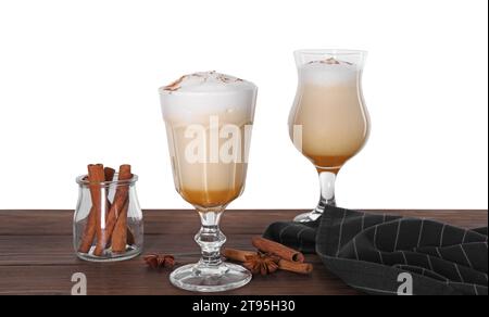 Délicieux lait de poule dans des verres et des épices sur la table en bois sur fond blanc Banque D'Images