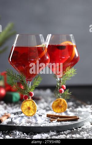 Cocktail Sangria de Noël dans des verres et de la neige sur une table en bois sombre Banque D'Images