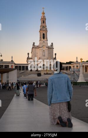 Les gens marchent le chemin pénitenciel à genoux vers la chapelle des apparitions. Sanctuaire de notre-Dame du Rosaire de Fátima à Fátima, Portugal. Banque D'Images