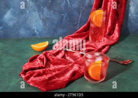 Verres de savoureux cocktail Negroni et tissu sur fond de couleur Banque D'Images