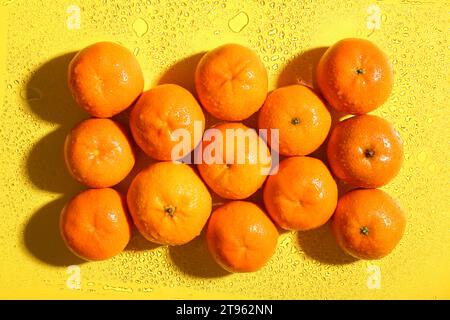 Mandarines douces dans l'eau sur fond jaune Banque D'Images