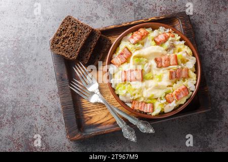 Norwegian Plukfisk se compose de pommes de terre, de morceaux de poisson et d'oignons cuits dans une sauce béchamel en gros plan sur une assiette sur la table. Vue de dessus horizontale Banque D'Images