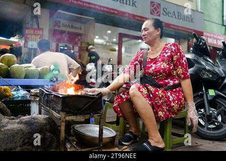 Hanoi, Vietnam - 9 novembre 2023 : une femme est vue en train de cuisiner de la nourriture de rue dans les rues de Hanoi. L'économie vietnamienne est l'une des plus dynamiques d'Asie, mais un environnement extérieur difficile et une demande intérieure plus faible ont entraîné un ralentissement de l'économie vietnamienne, avec une croissance de 4,7 % en 2023 contre 8 % en 2022, tandis que l'industrie du tourisme continue de croître, avec plus de 10 millions de visiteurs prévus pour 2023, ce qui en fait la destination la plus populaire en Asie du Sud-est après la Thaïlande. (Photo Davide Bonaldo/Sipa USA) Banque D'Images