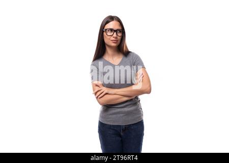 jeune femme européenne brune mignonne vêtue d'un t-shirt de base gris Banque D'Images