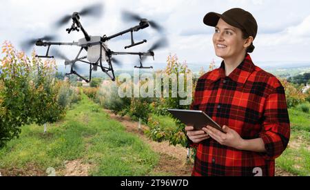 Un pulvérisateur de drone survole les pommiers. Agriculture intelligente et agriculture de précision. Banque D'Images