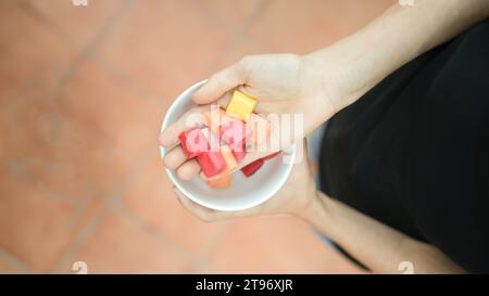 Vue rapprochée de dessus des mains blanches montrant des bonbons colorés dans un parc avec espace copie gauche Banque D'Images