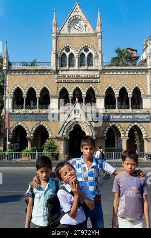 De jeunes garçons indiens posent devant le bâtiment patrimonial David Sassoon Library construit en 1867-70, à Kala Ghoda, fort, Mumbai, Inde Banque D'Images