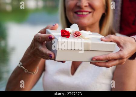 Gros plan d'une femme méconnaissable âgée recevant un cadeau d'amour le jour de la Saint-Valentin Banque D'Images