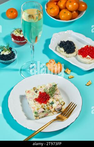 Table du nouvel an ou de Noël pour la fête dans le style russe avec champagne en verre, mandarines et salade Olivier en portions sur assiette décorée wi Banque D'Images