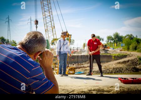 L'ingénieur Surveyor mesure le niveau sur le chantier. Les arpenteurs assurent des mesures précises avant d'entreprendre de grands projets de construction, en backgr Banque D'Images