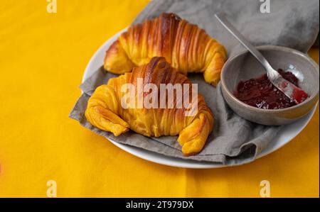 Croissants briochés sur une assiette avec un petit bol de confiture Banque D'Images