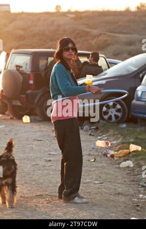 Femme, alcool et bière en plein air dans la nature pour fête, événement ou rassemblement social dans les prairies ou la forêt. Personne, parking et voitures pour les vacances Banque D'Images