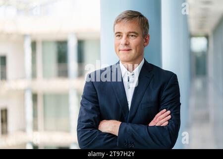 Homme d'affaires prospère debout avec les bras croisés devant la colonne Banque D'Images
