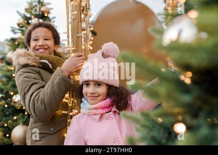 Heureux frère et sœur appréciant près des arbres de Noël Banque D'Images