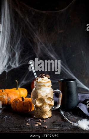 Mug en forme de crâne ofÂ citrouille spiceÂ latte avec crème fouettée et graines de citrouille caramélisées Banque D'Images